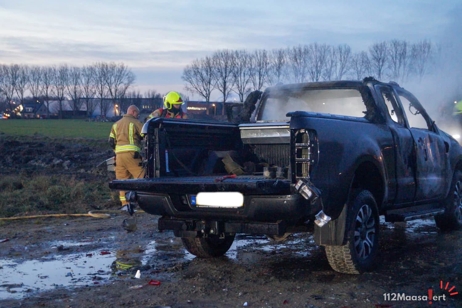 Pickup truck in brand op bouwterrein in Maassluis